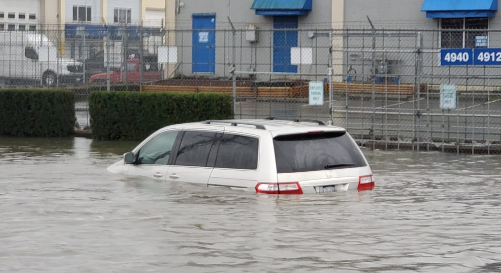 A vehicle is seen partially submerged in a flooded area near Still Creek Drive in Burnaby on Oct. 19, 2024. (David Nadalini/1130 NewsRadio Image)