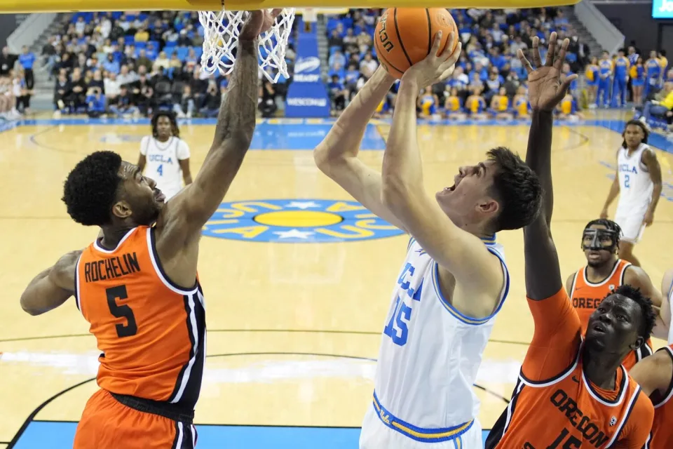 UCLA center Aday Mara shoots under pressure from Oregon guard Justin Rochelin, left, and center Chol Marial on Feb. 1 in Los Angeles. (Mark J. Terrill / Associated Press)