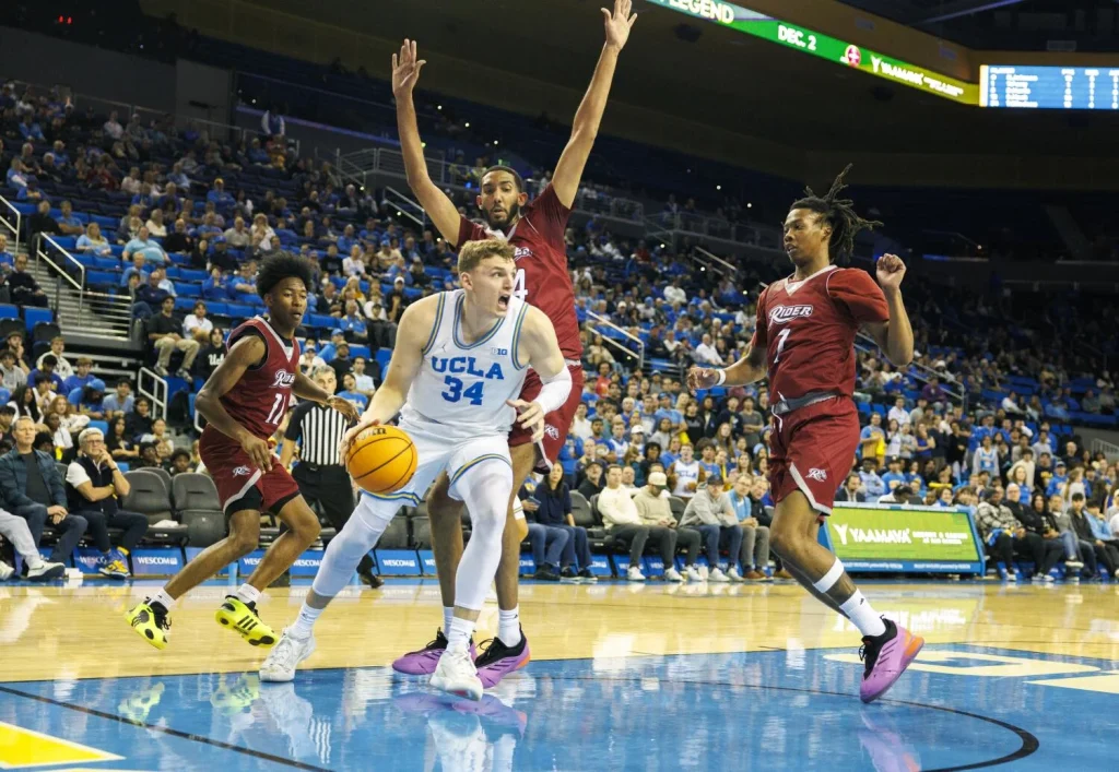 UCLA forward Tyler Bilodeau drives under the basket near Rider center Alaaeddine Boutayeb (14) and Rider Broncs forward Ife West-Ingram (7) at Pauley Pavilion on Monday. (Gina Ferazzi/Los Angeles Times)