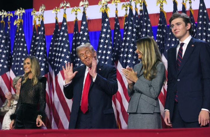 Republican presidential nominee and former U.S. President Donald Trump gestures as he stands on stage with his wife Melania, his son Barron and Lara Trump